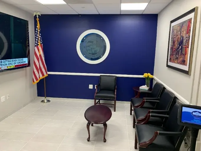 A room with chairs and a flag on the wall.