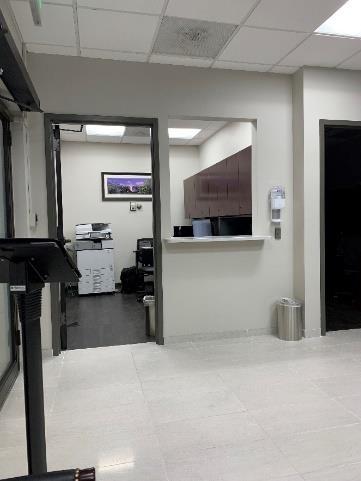 A view of the entrance to a room with a desk and a mirror.