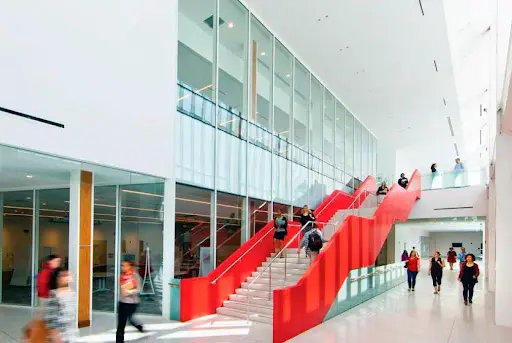 A red staircase in the middle of an office building.